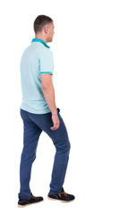 Fototapeta premium Back view of going handsome man in jeans and a shirt.