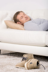 Young man sleeping on sofa at home.