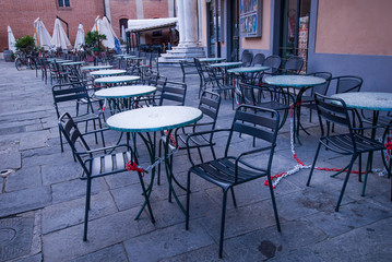 Fila di tavolini e seggiole vuoti, caffe, gelateria, bar