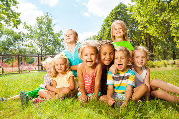 Fototapeta premium Group of happy little kids on the lawn in park