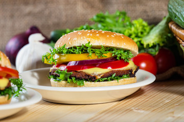 homemade hamburger with fresh vegetables on cutting board