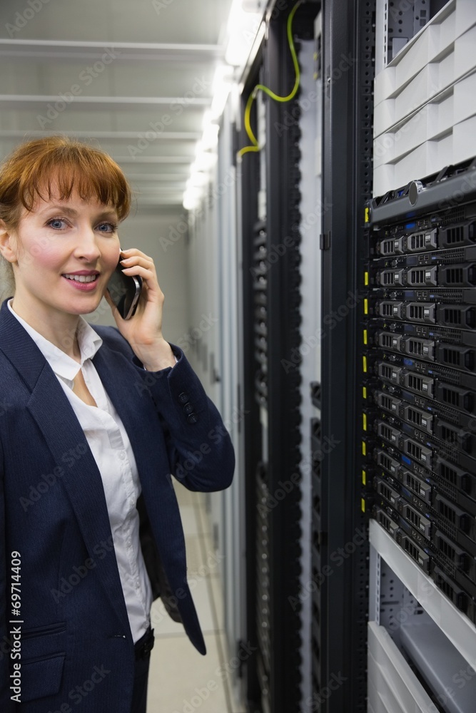 Aufkleber Smiling technician talking on phone while looking at server