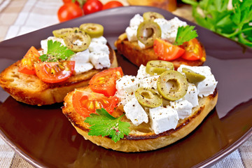 Sandwich with feta and olives on tablecloth