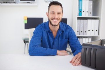 Computer engineer sitting at desk smiling at camera