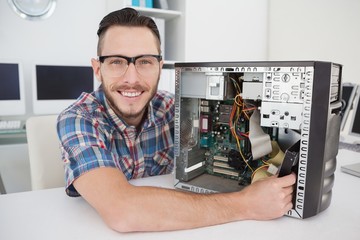 Fototapeta na wymiar Computer engineer working on broken console smiling at camera