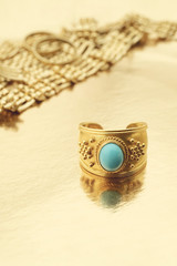 Gold ring with jewelry on gold background with copy space..