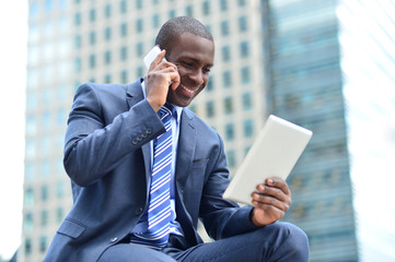 African executive with tablet pc and cellphone