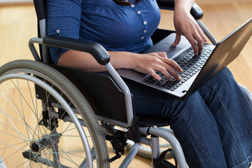 Fototapeta na wymiar Woman on a wheelchair with laptop