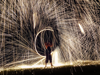 Firestarter performing amazing fire show with sparkles nightime