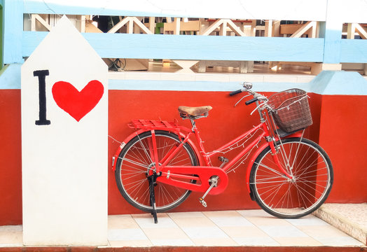 Red vintage bicycle with " I Love " paint