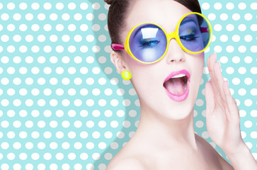 Attractive surprised young woman wearing sunglasses