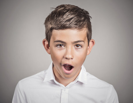 Boy shocked surprised in disbelief, grey wall background