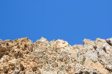 rocky cliff over clean blue sky