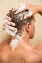 Naklejka premium back view of man showering in bathroom