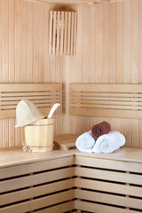 Traditional wooden sauna for relaxation with bucket of water and