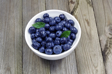 blueberries in porcelain bowl on wooden table