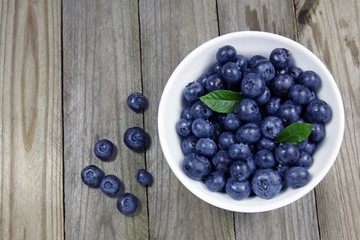 blueberries in porcelain bowl on wooden background