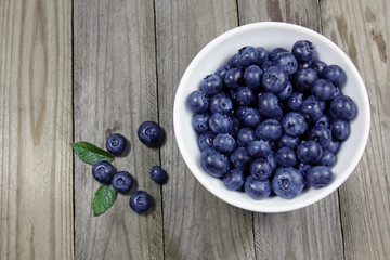 blueberries in porcelain bowl on wooden background