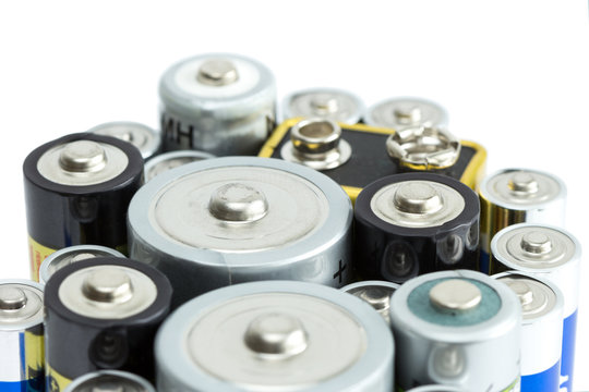 Closeup of variety of batteries, isolated on white background