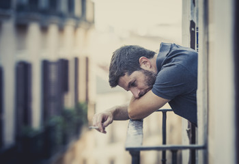 young man at balcony in depression suffering emotional crisis