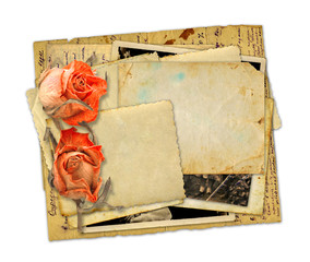 Pile of old photos and letters with bouquet of dried roses on wh