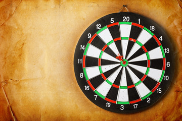 Vintage dart board on dark wall grunge