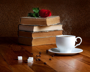 Hot cup of fresh coffee on the wooden table and stack of books t