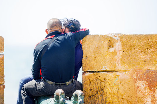 A romantic kissing couple on top of the wall