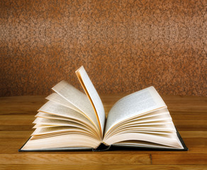 Old open book on grunge wooden table