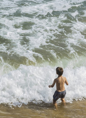 Fototapeta premium Niño jugando en el mar