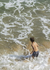 niño jugando en el mar