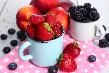 Sweet berries in cup on table close-up