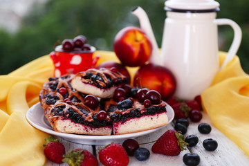Sweet berry tart with berries on table on natural background