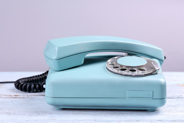 Retro turquoise telephone on wooden table, close up