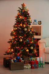 Decorated Christmas tree on home interior background at night