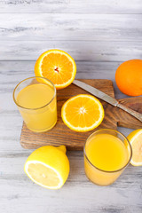 glasses of juice with fresh fruits on grey wooden table
