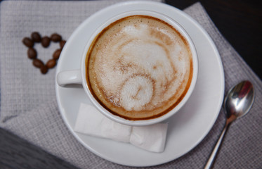 Cup of coffee with cute drawing in cafe