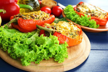 Stuffed red peppers with greens and vegetables on table close