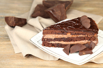 Chocolate cake on plate, on wooden background