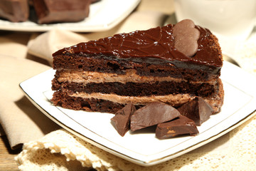 Chocolate cake on plate, on wooden background