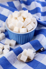 Refined sugar in color bowl on color napkin background