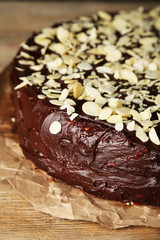 Tasty chocolate cake with almond, on wooden table