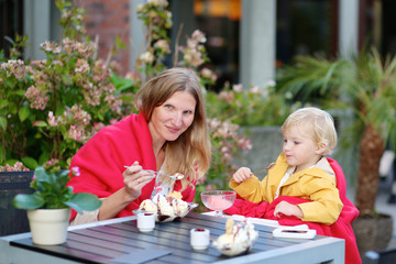 Mother and daughter eating ice cream in cafe