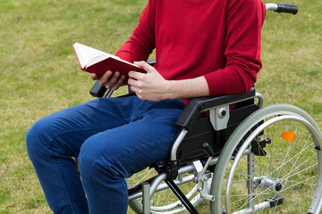 Obraz premium Disabled man reading book in the garden