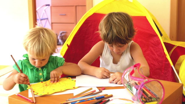 calm children sketching on paper in home interior