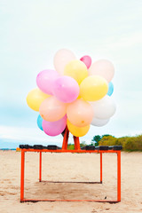 The party is over. Bunch of colored balloons on bench.