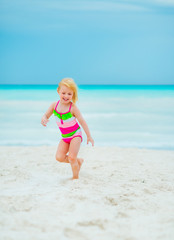 Portrait of happy baby girl running on beach