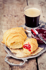 Coffee and croissants on tray on wooden background