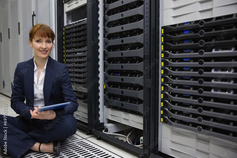 Aufkleber technician sitting on floor beside server tower using tablet pc
