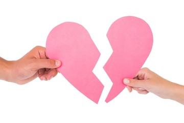Couple holding two halves of broken heart